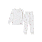 A two-piece children's pajama set featuring a long-sleeve top and matching pants in white, both printed with a delicate pink and gray pattern of tiny figures and stars.