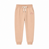A pair of light peach-beige jogger sweatpants with an elastic waistband, white drawstring, and a small pink bow graphic on the left thigh, shown against a plain white background.