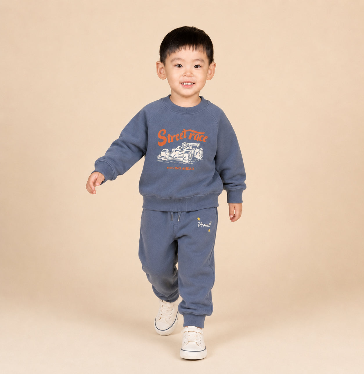 Child wearing a blue sweatshirt and pants with a 'Speed Time' graphic on a beige background