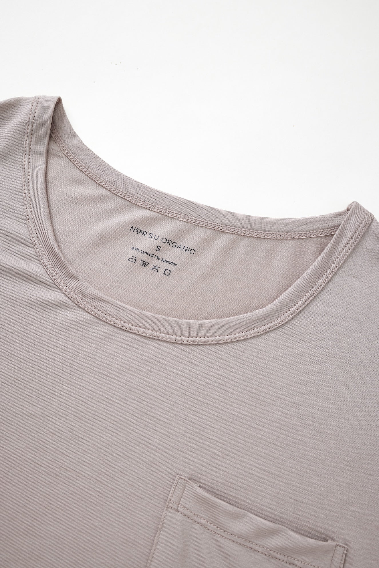 Close-up of a light gray t-shirt with a brand label on the collar.