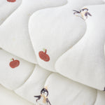 White blanket with cartoon character and apple design on a white background