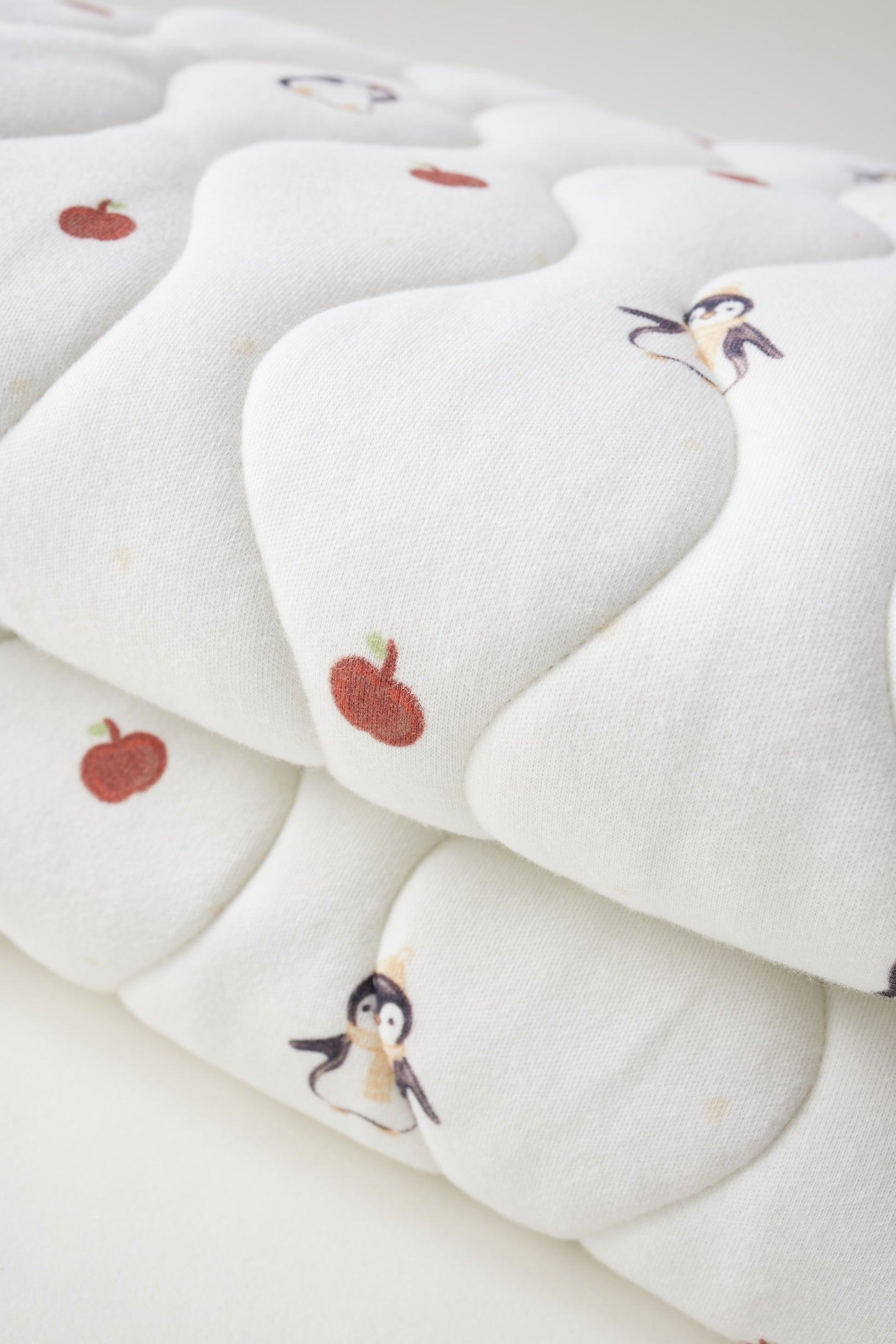 White blanket with cartoon character and apple design on a white background