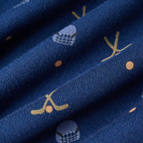 A close-up of navy blue knit fabric with a repeating pattern of small gold crescent moons, orange dots, and light blue-and-white geometric motifs.