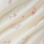 A close-up of a soft cream-colored fabric with a delicate, repeating pink ballet dancer pattern.