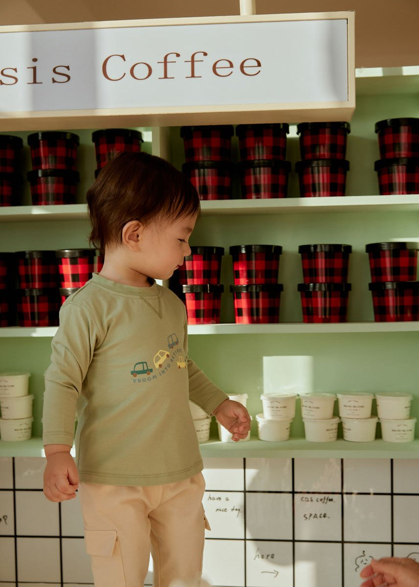 baby boy is looking at his ice cream cup