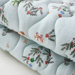 Decorative cushion with floral and ribbon pattern on a light blue background