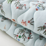 Decorative cushion with floral and ribbon pattern on a light blue background