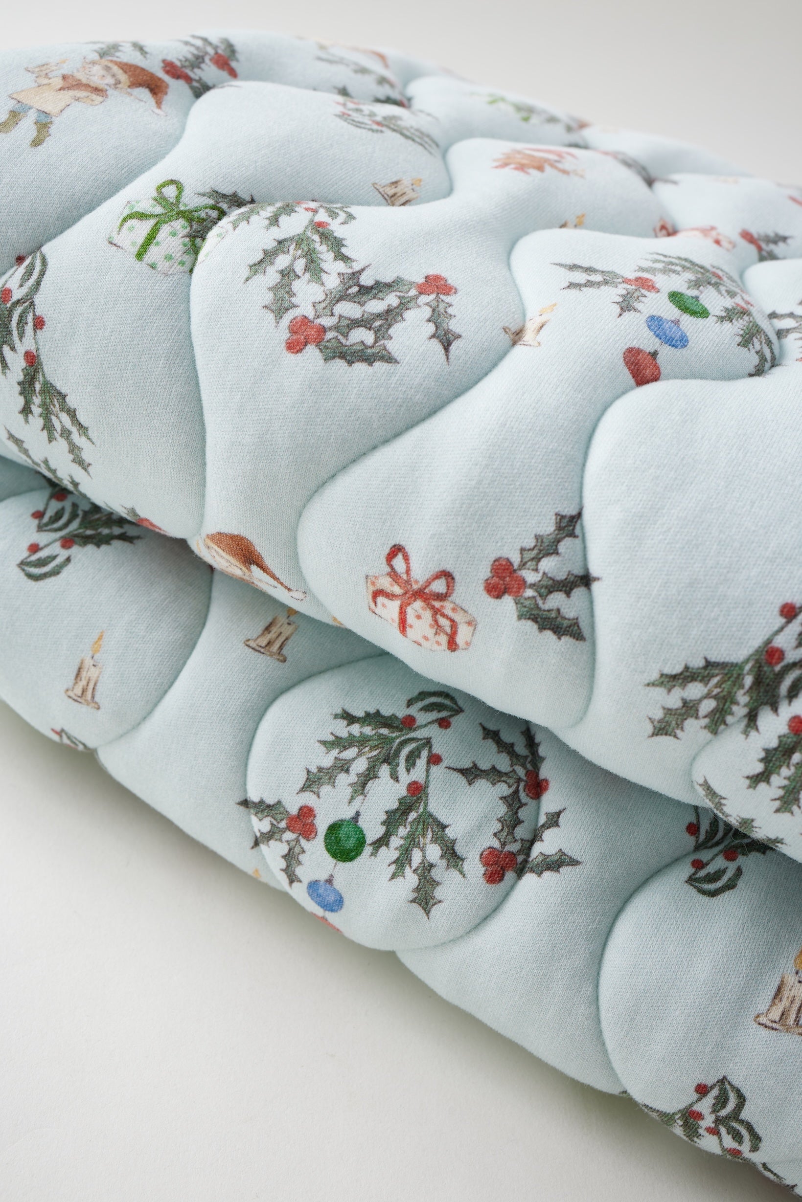 Decorative cushion with floral and ribbon pattern on a light blue background
