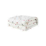 Folded white blanket with red patterns on a white background