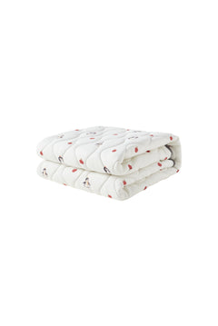 Folded white blanket with red patterns on a white background