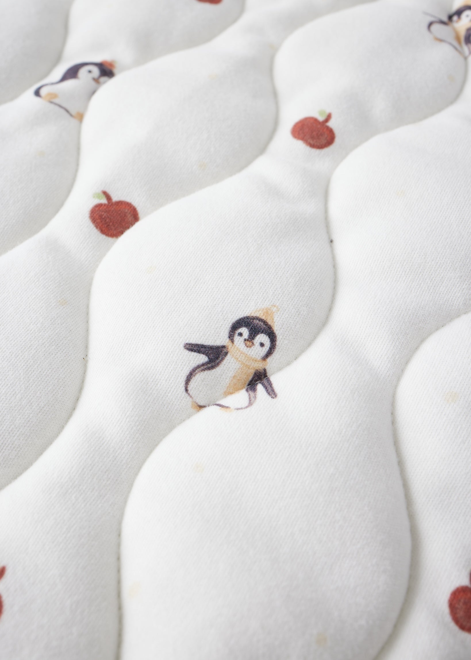 White fabric with penguin and apple pattern