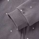 Close-up of a dark gray sweatshirt with star patterns on a plain background