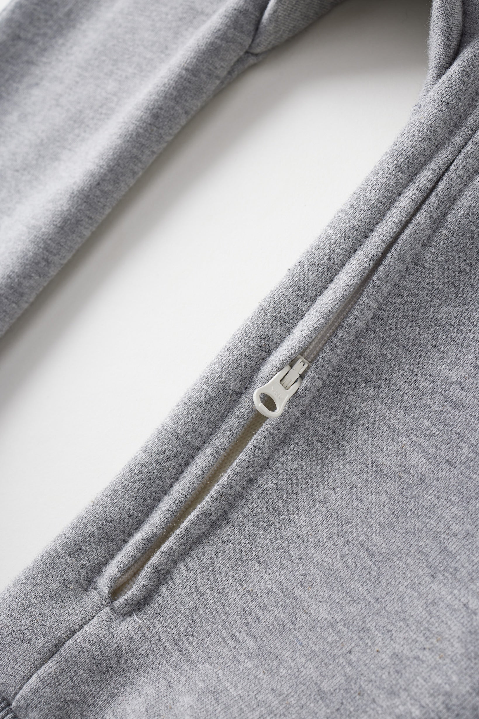 Close-up of a gray zip-up hoodie on a white background