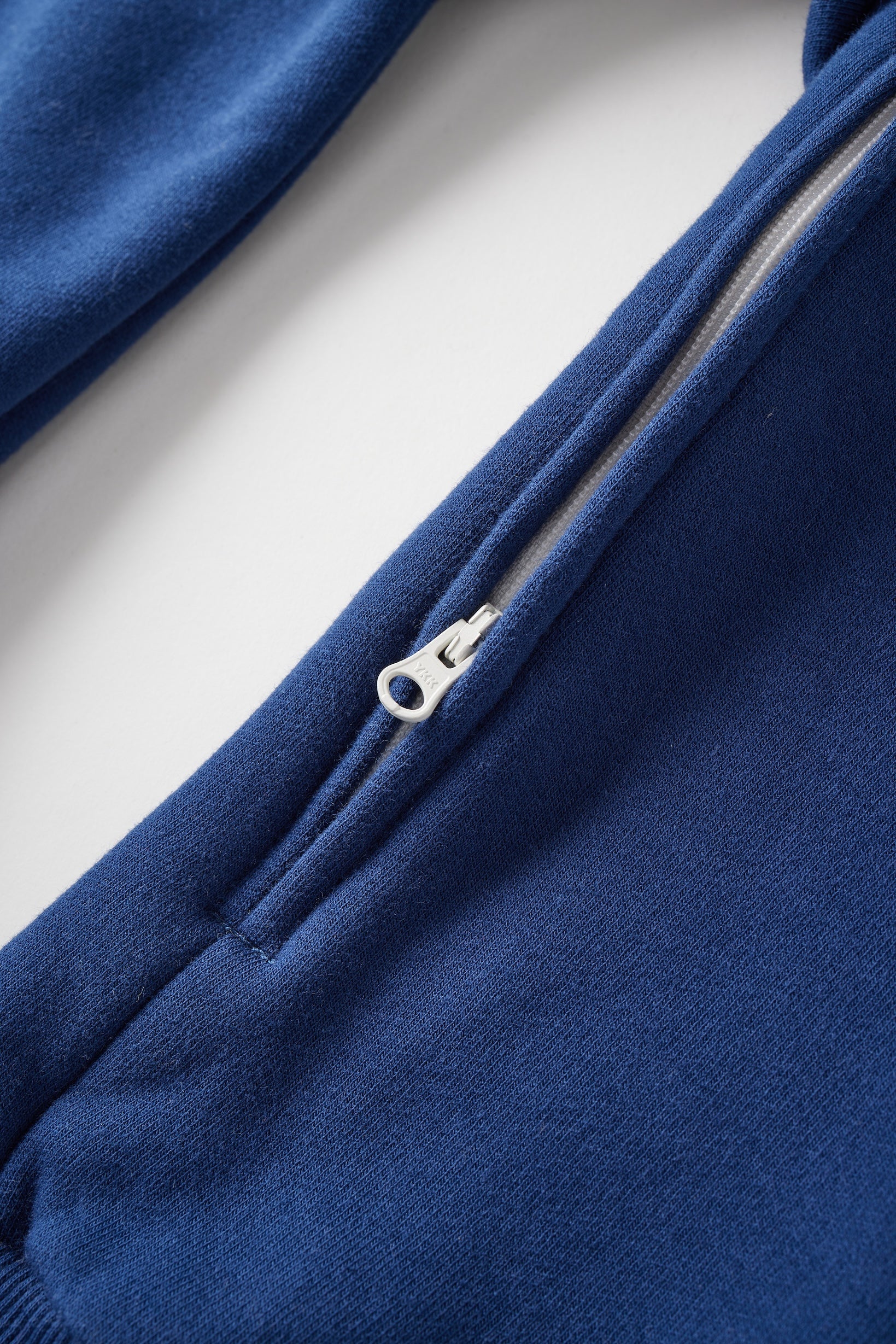 Close-up of a blue jacket with a zipper on a light gray background