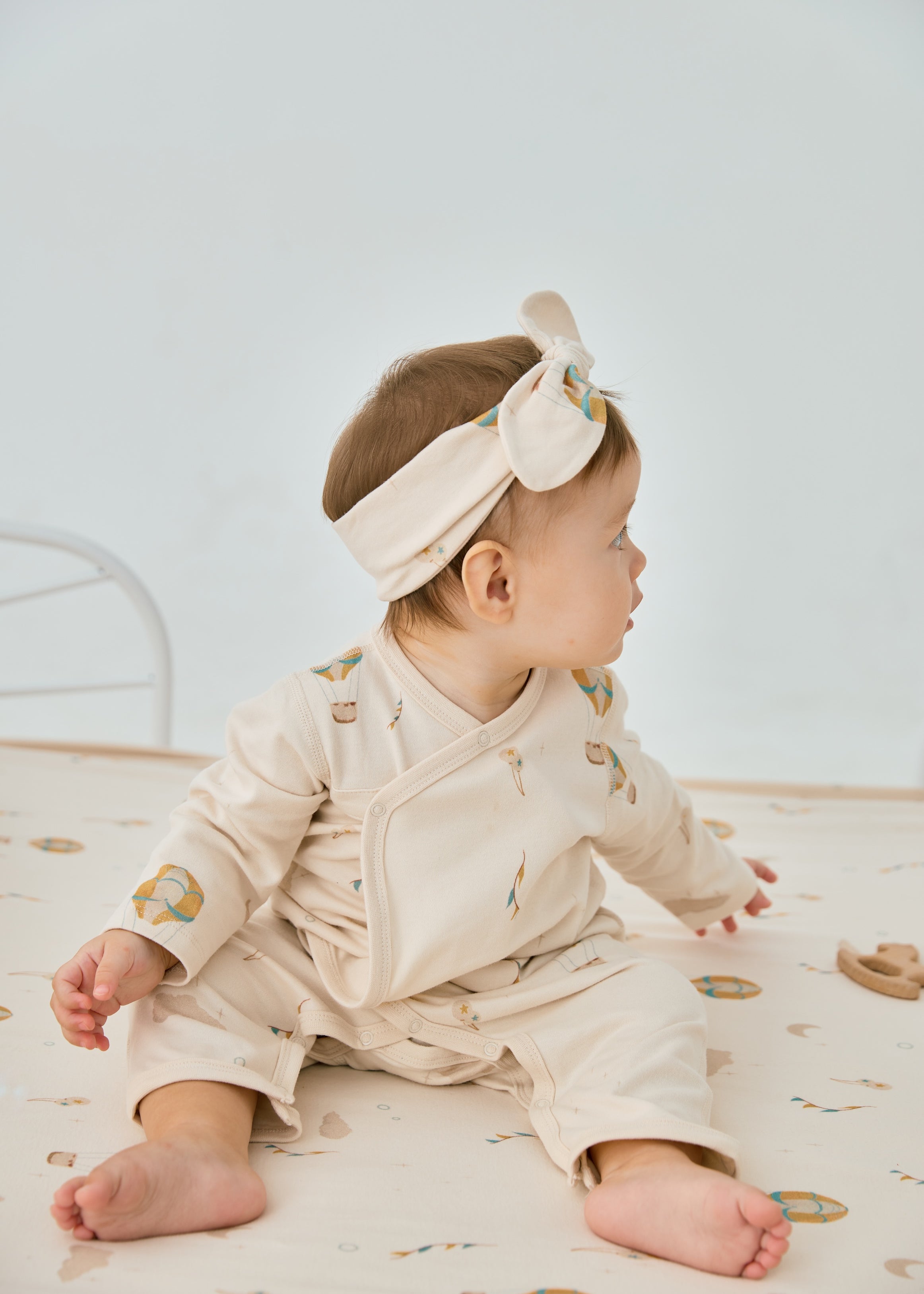 young girl on the bed trying to get a toy