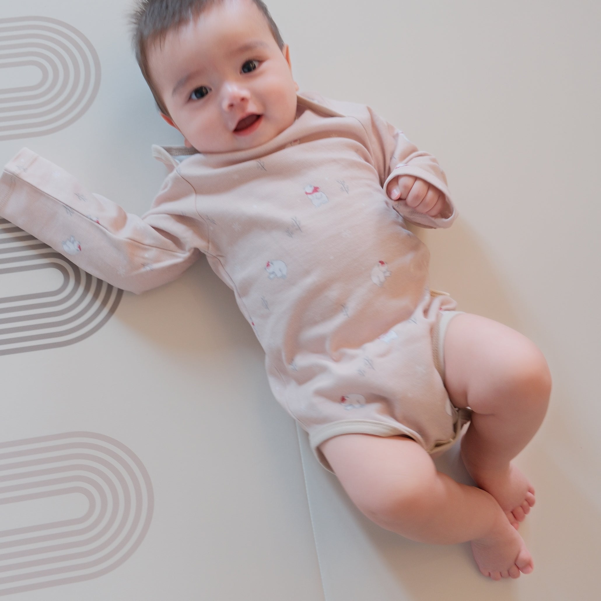 Baby lying on a white mat with a soft focus background