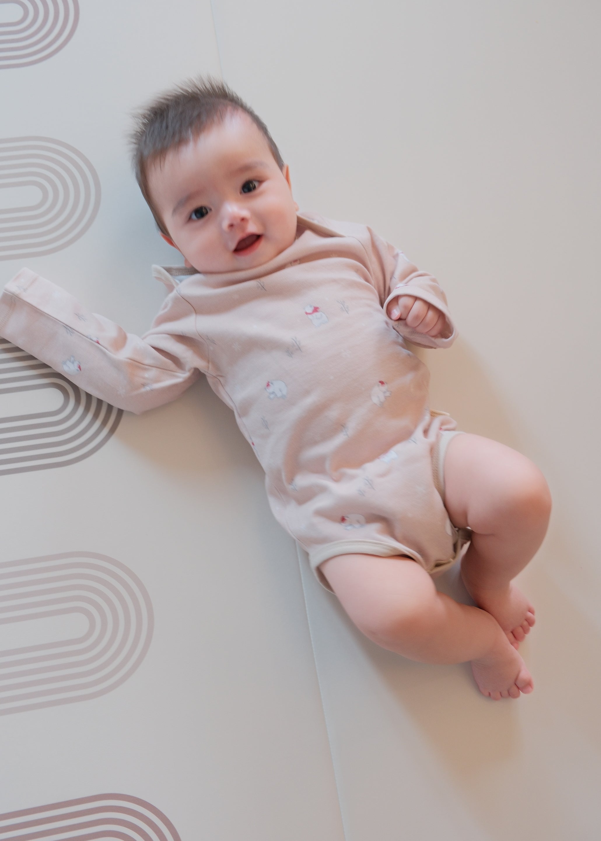 Baby lying on a white mat with a soft focus background