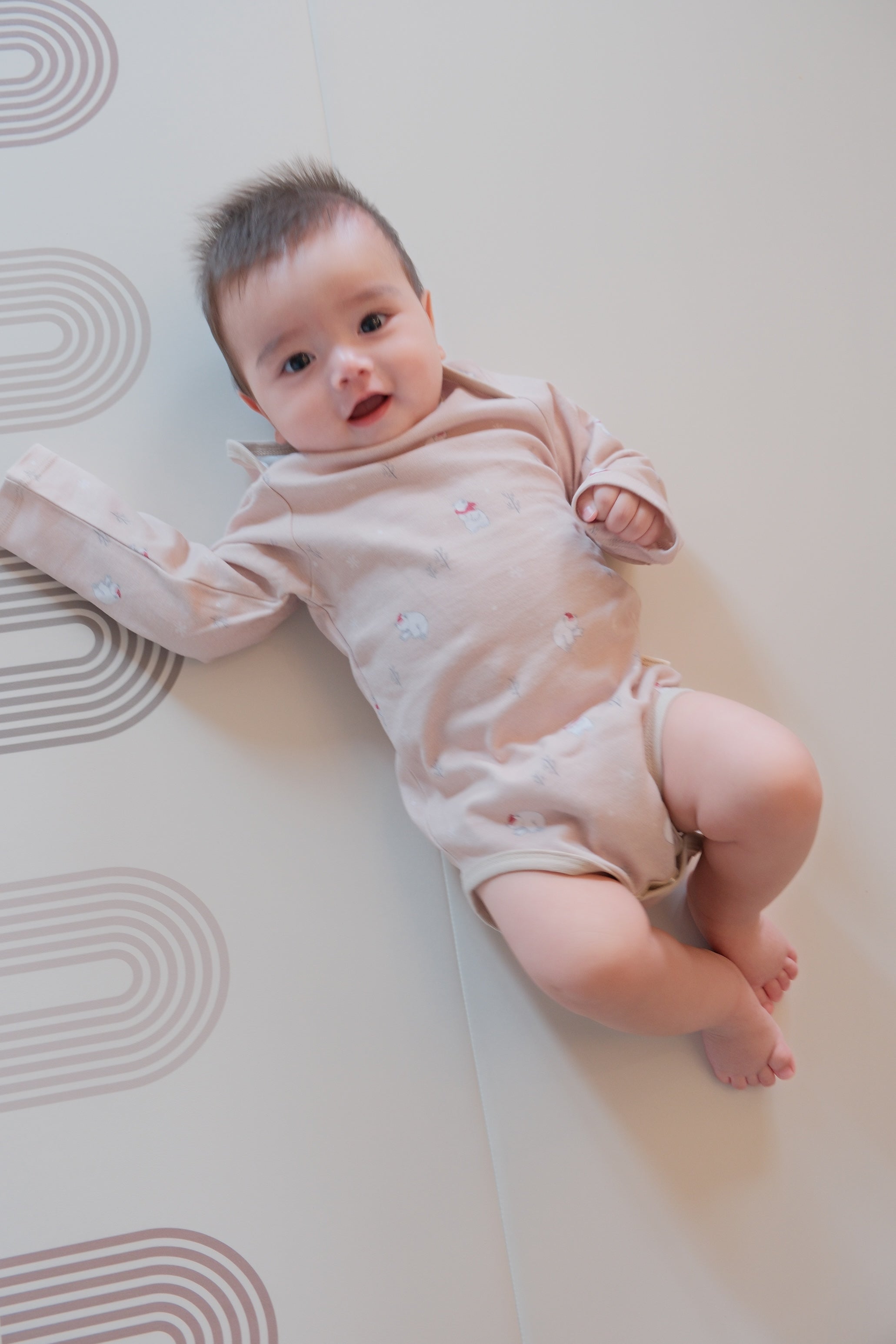 Baby lying on a white mat with a soft focus background