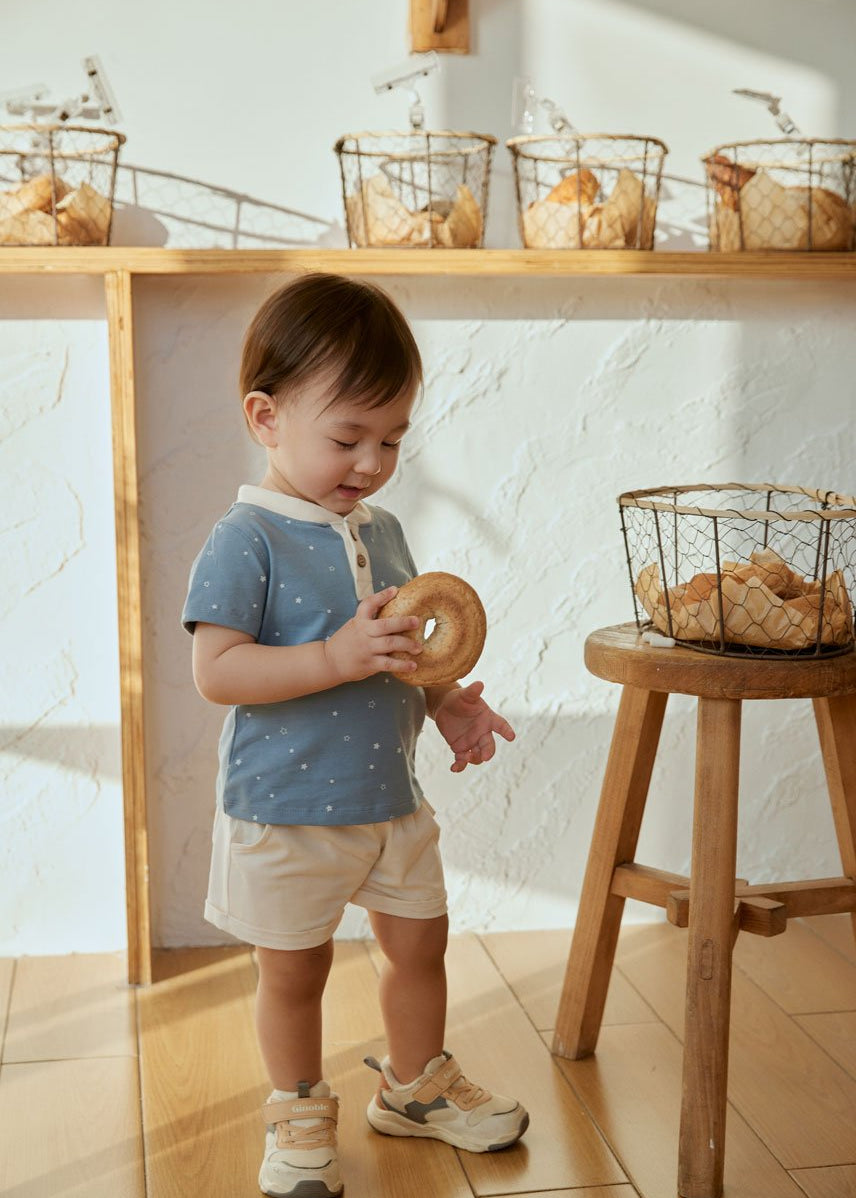 baby is holding a begal and trying to eat