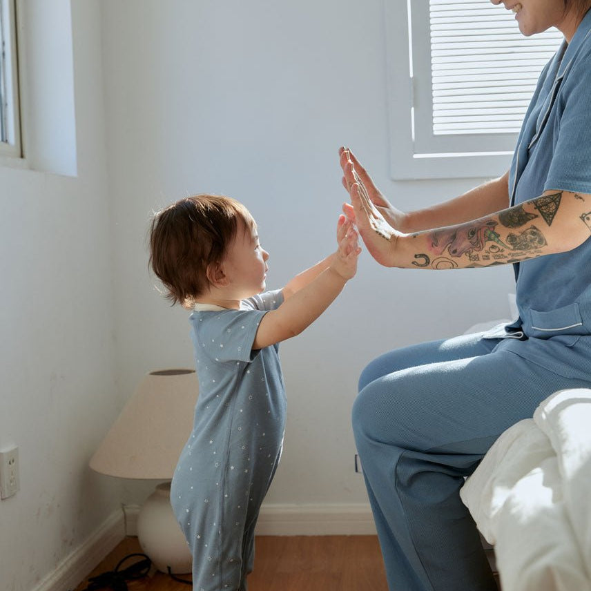 baby boy is high five with his mom