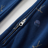 Close-up of a blue garment with a zipper and embroidered designs on a white background