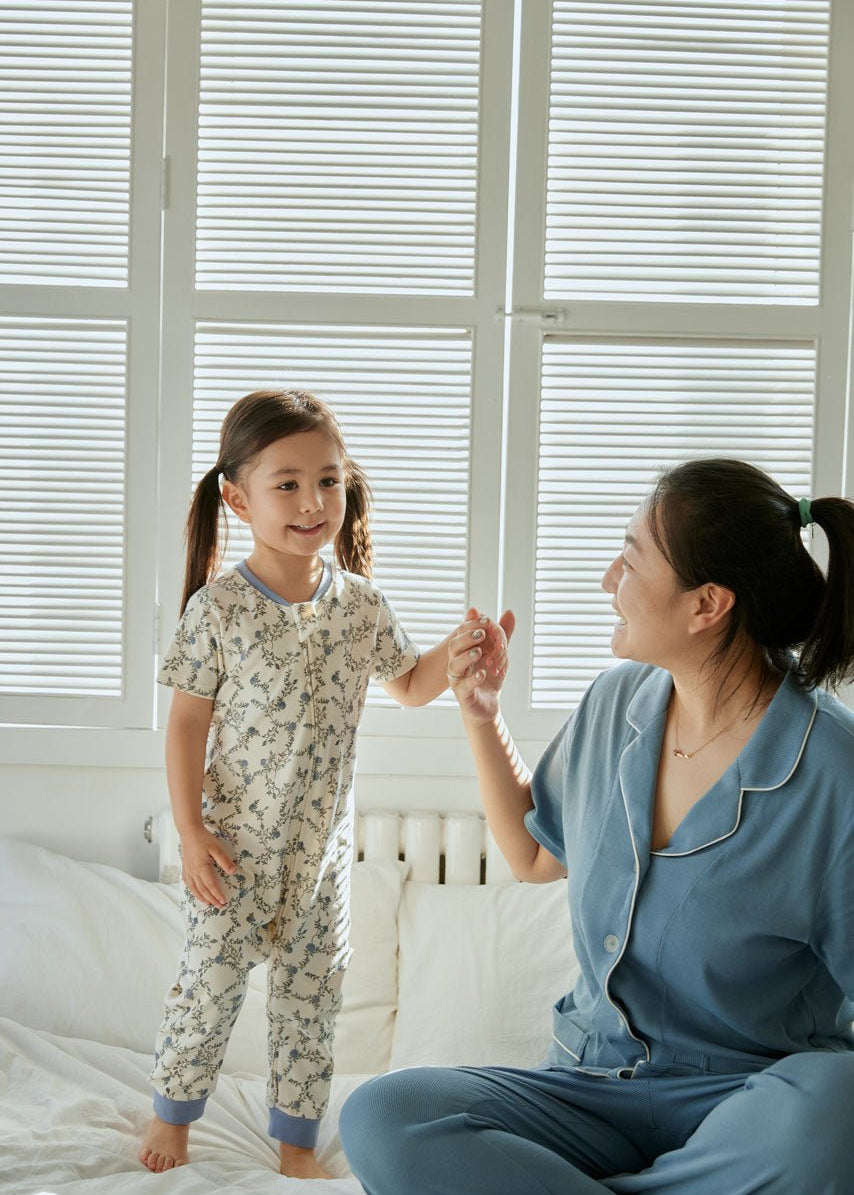 baby girl sit on the bed with her mom