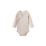 Beige baby onesie with polar bear patterns on a white background