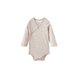 Beige baby onesie with polar bear patterns on a white background