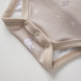 Beige baby onesie with embroidered snow polar bear on a light background