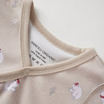 Close-up of a baby outfit with polar bear and snowflake pattern on a neutral background