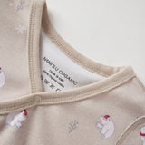Close-up of a baby outfit with polar bear and snowflake pattern on a neutral background