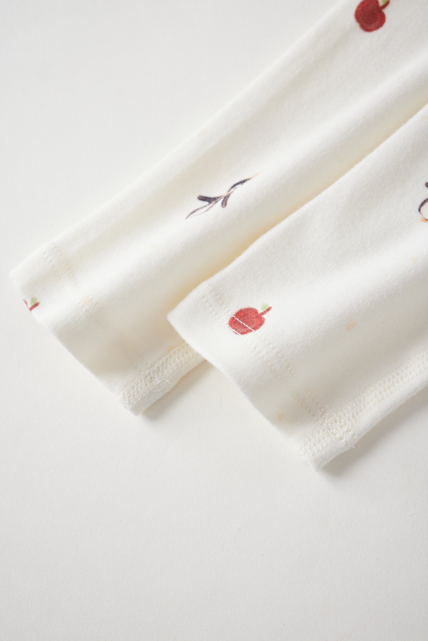 sleeper's sleeve with red floral embroidery on a light gray background
