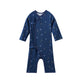 Navy blue baby sleeper with hockey pattern on a white background