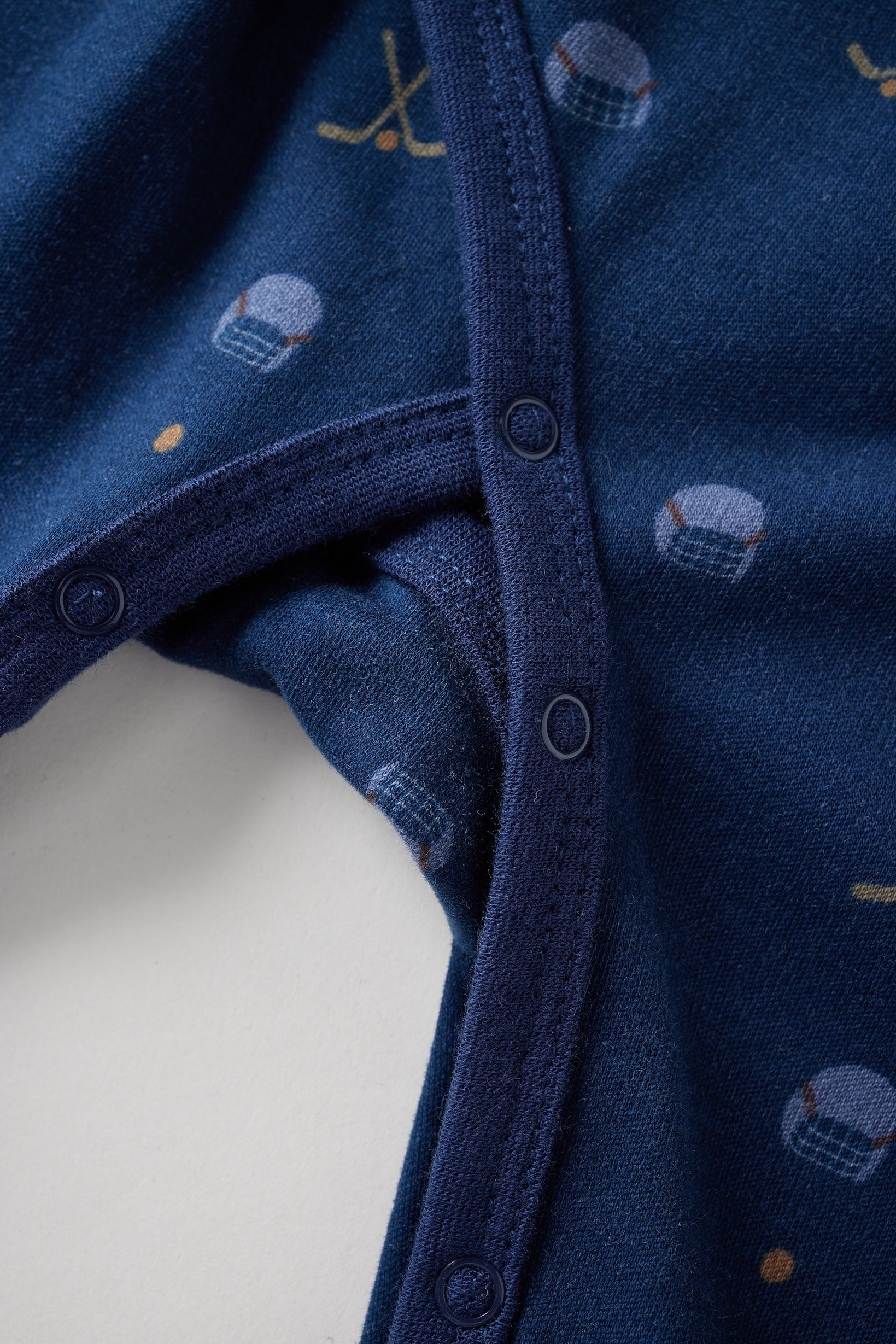 Close-up of a blue baby sleeper with small patterns on a white background