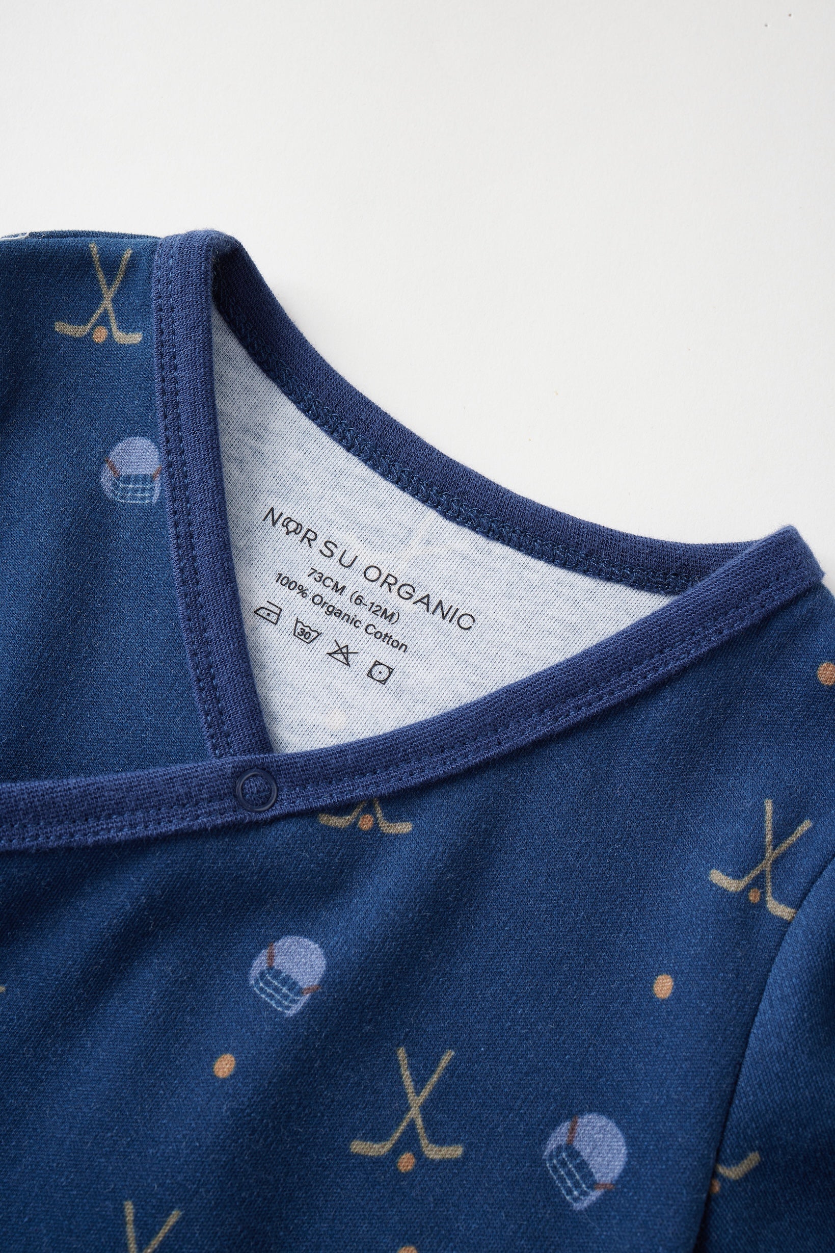 Close-up of a blue baby outfit with a label on a white background