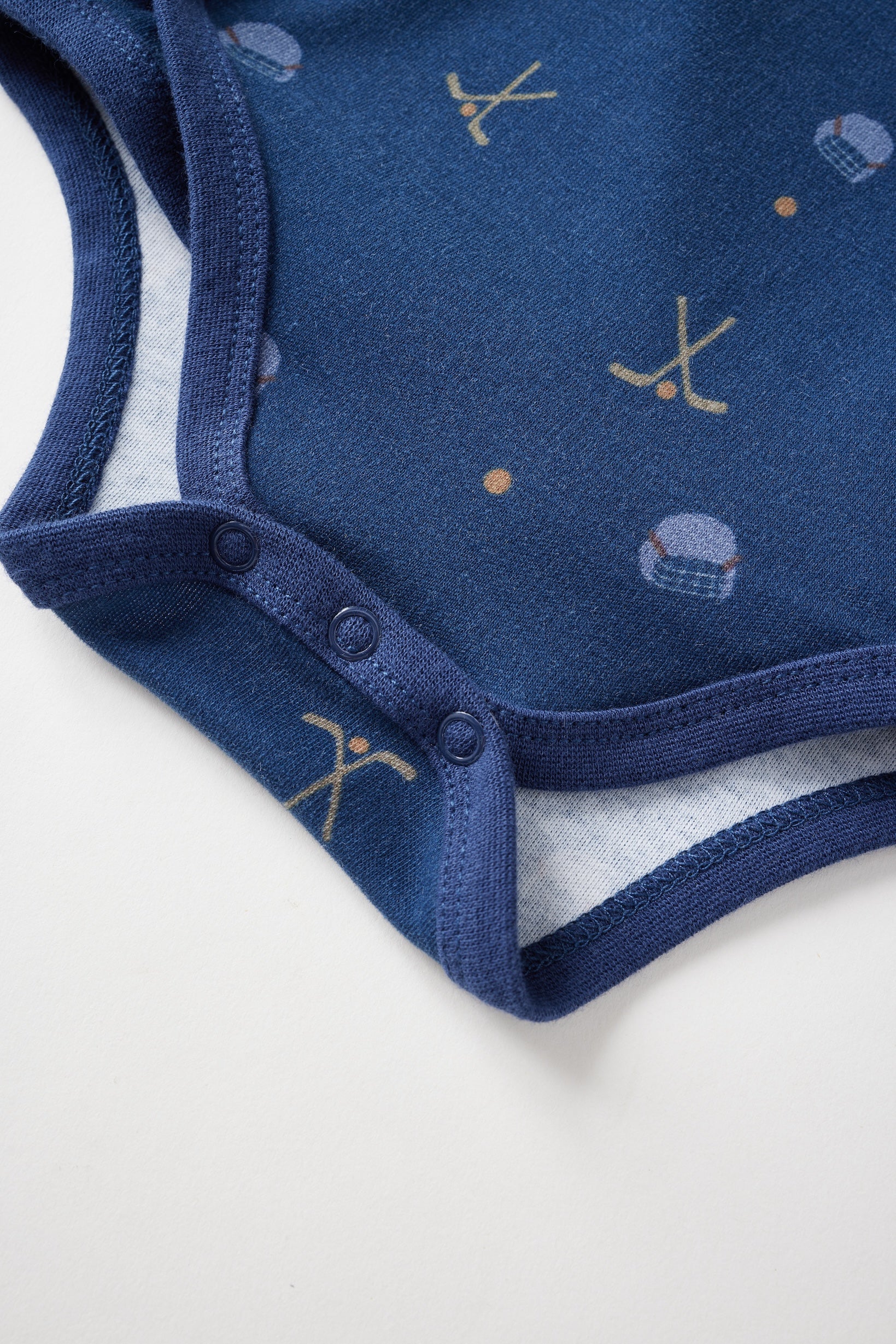 Navy blue baby onesie with pattern on a white background