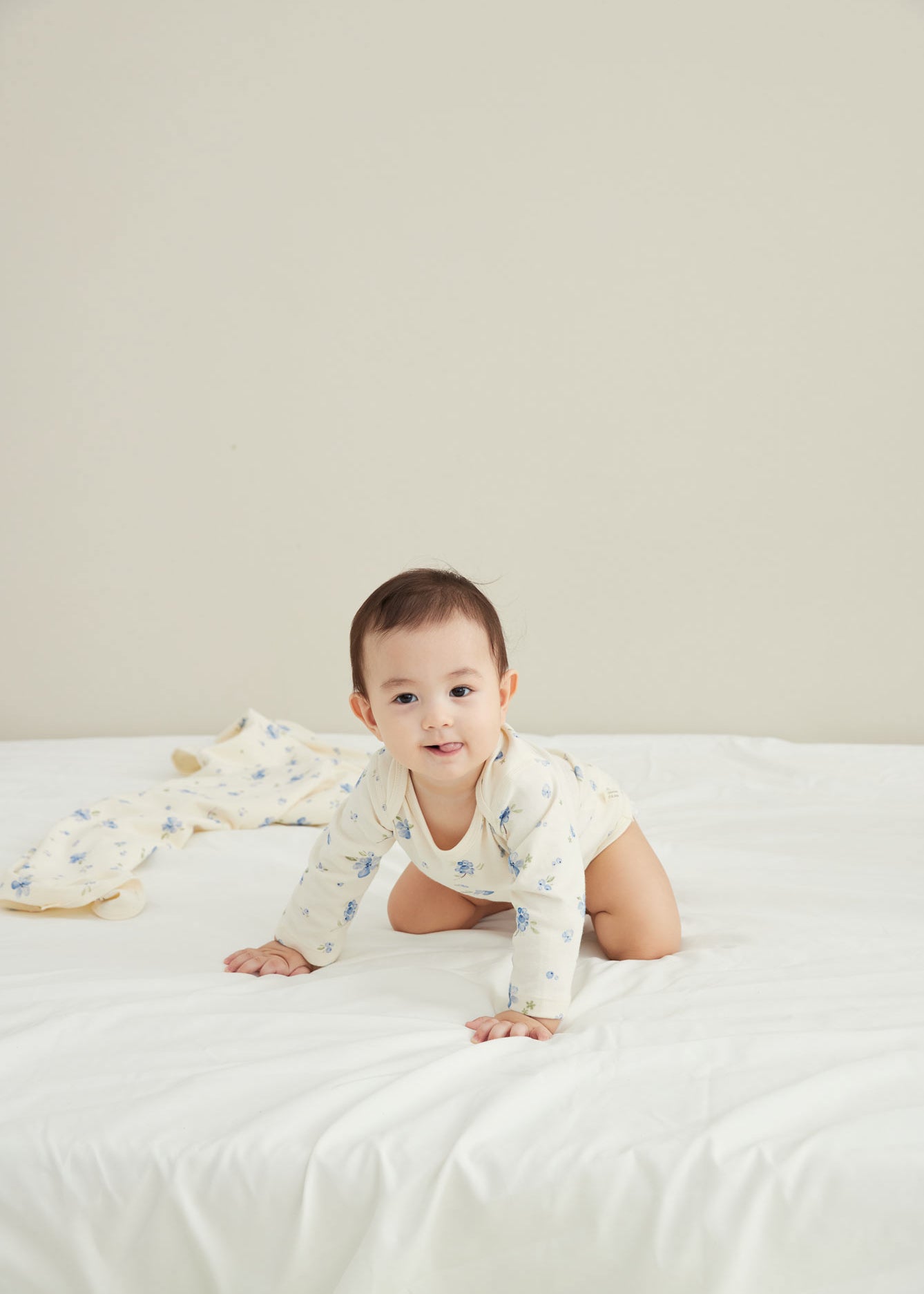 model smiling with Baby Organic Long-sleeve Onesie-Blueberry
