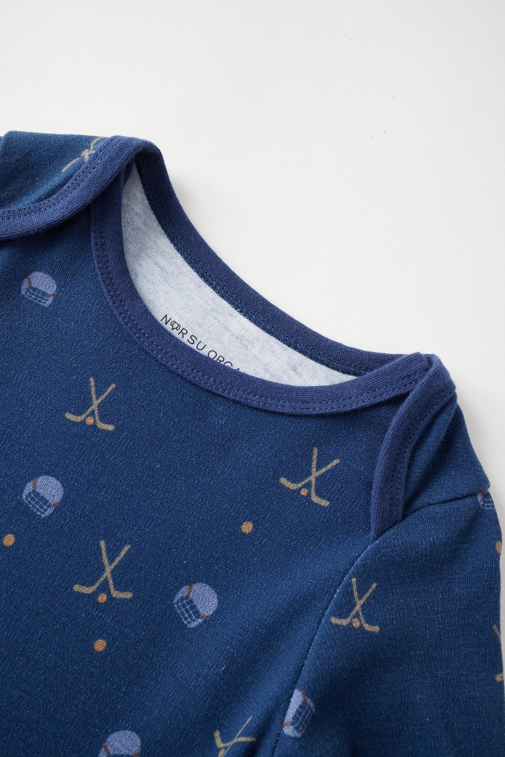 Blue baby onesie with hockey pattern on a white background