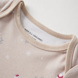 Close-up of a beige baby onesie with polar bear designs and 'Norsu Organic' label.