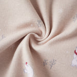 Close-up of beige fabric with embroidered polar bear and tree patterns