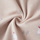 Close-up of beige fabric with embroidered polar bear and tree patterns