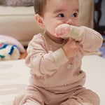 Baby in polar bear outfit holding a pink toy