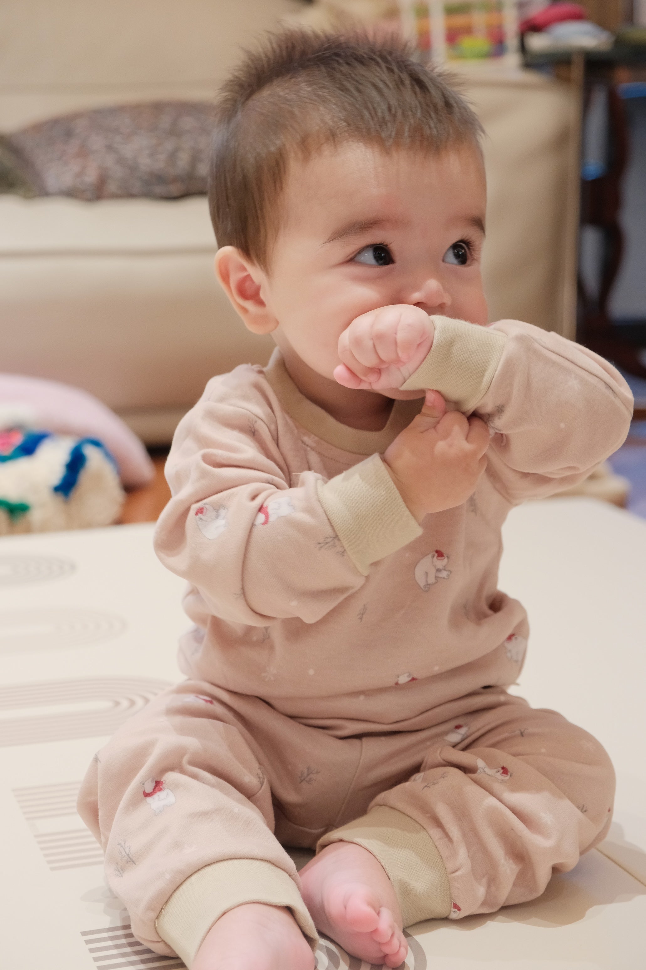 Baby in polar bear outfit holding a pink toy