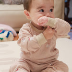 Baby in polar bear outfit holding a pink toy