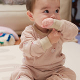 Baby in polar bear outfit holding a pink toy