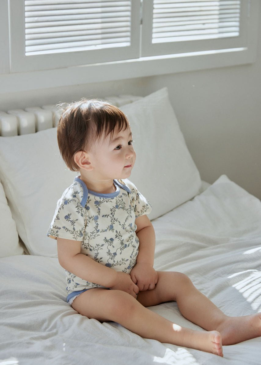 baby sitting on the bed and wearing Baby Organic Short-Sleeve Onesie-Roses