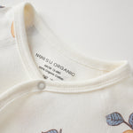Close-up of a baby outfit with 'NORSU ORGANIC' label on a white background