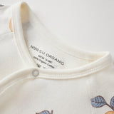 Close-up of a baby outfit with 'NORSU ORGANIC' label on a white background