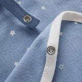 Close-up of a blue baby shirt with white star patterns and white trim.
