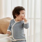 Child wearing a blue starry outfit with white trim in a bright room